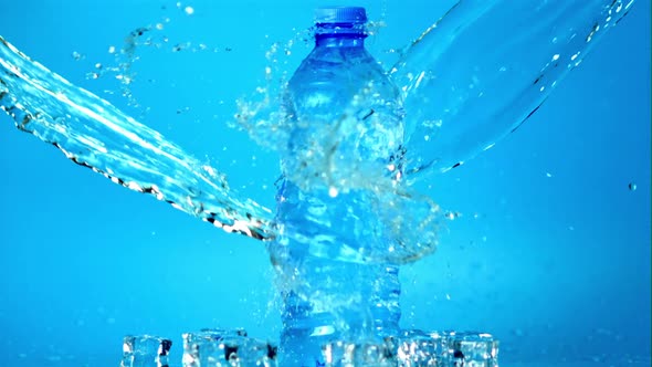 Super Slow Motion Jet of Water Falls on the Water Bottle on the Table