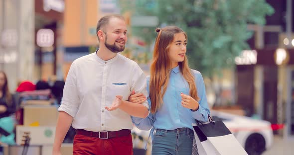 Beautiful Young Couple Walking and Talking in the Mall