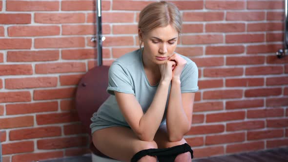 Upset Young Pensive Domestic Woman Feeling Pain Sitting on Toilet Medium Shot