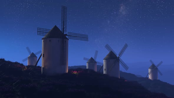 Multiple old, vintage, Spanish windmills rotating slowly at night. 4K HD