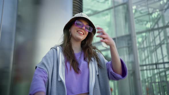 Portrait of Happy Hipster Woman Typing By Mobile Phone Outdoors