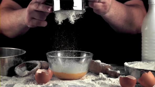 Super Slow Motion Men's Hands Sprinkle Flour in a Bowl for Baking