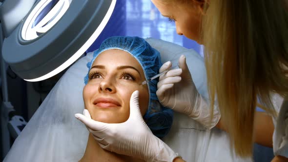 Doctor inserting facial injection on female patient face