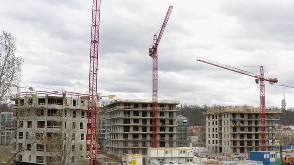 Red tower cranes working at construction site of new buildings, Prague.