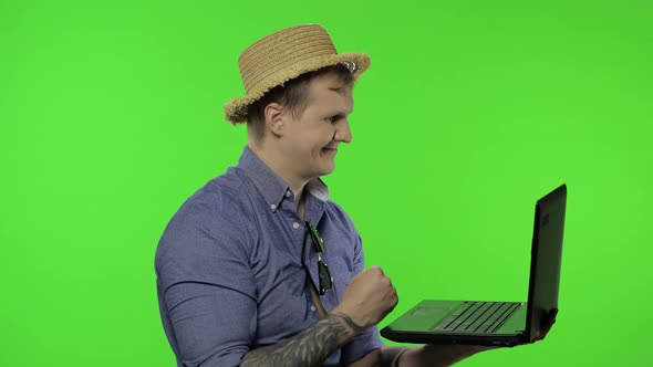 Portrait of Man Tourist Is Working on Vacation Using Laptop. Chroma Key