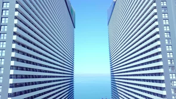 the drone flies between two buildings with glass windows.