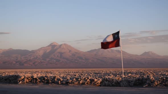 The flag of Chile waving in the amazing landscape of the Atacama desert