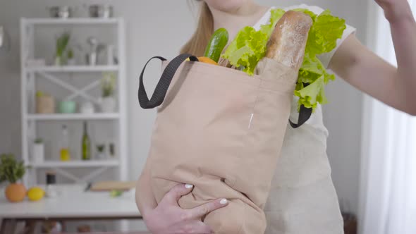 Unknown Caucasian Woman Holding Shopping Bag with Fresh Salad Leaves, Bread and Fruits