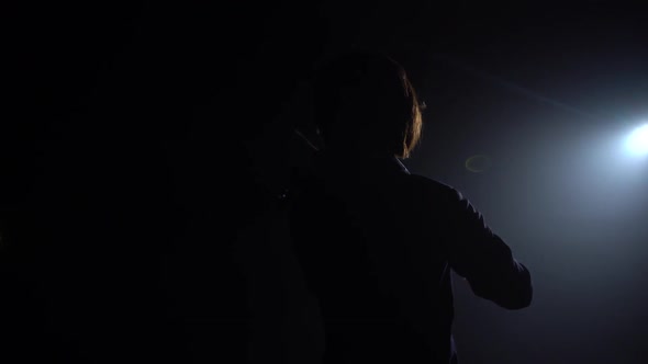 Musician Plays the Violin While Standing with His Back Glare From a Lantern. Black Smoke Background