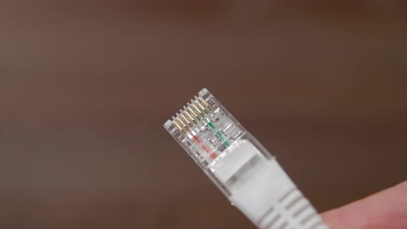 Network cable plug close up in hand. Ethernet connection equipment. Internet cord