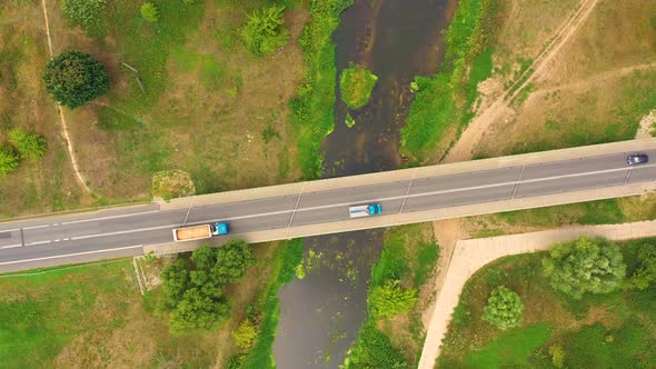 aerial drone shoot. Flying over a bridge green field in a rural landscape. Top view of trees in fore