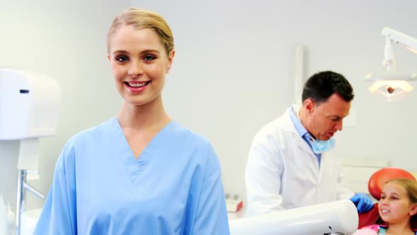 Smiling dental assistant standing in dental clinic