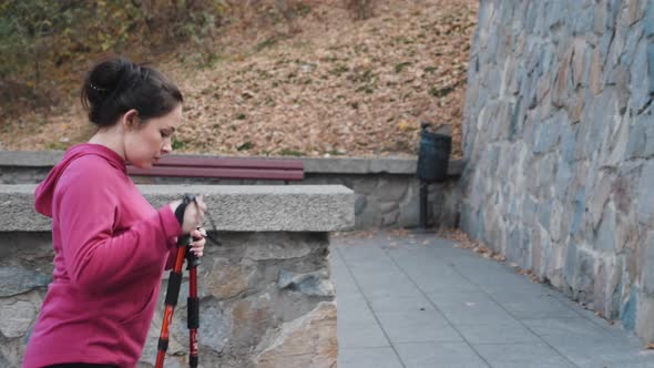 Young attractive woman with nordic poles going up the stairs doing cardio training. Nordic Walking