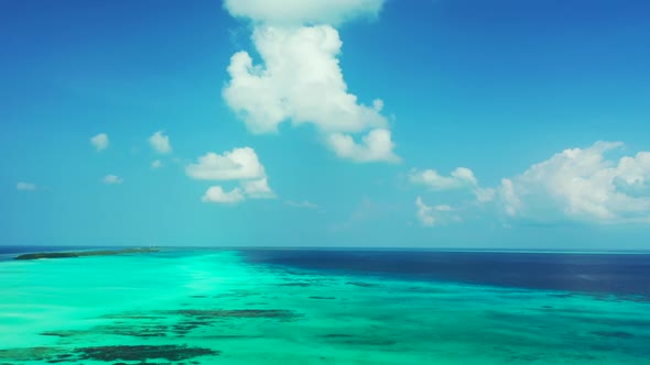 Aerial flying over seascape of marine resort beach lifestyle by blue green lagoon and white sandy ba