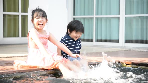 Asian Children Splashing Around In The Pool
