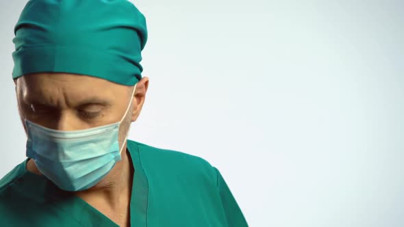 Doctor in Face Mask Nodding and Taking Syringe, Preparing to Make Injection