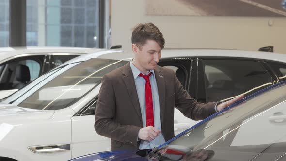 Mature Male Customer Examining Modern Automobile for Sale at the Dealership
