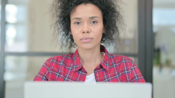 Close Up of African Woman with Laptop Looking in Camera