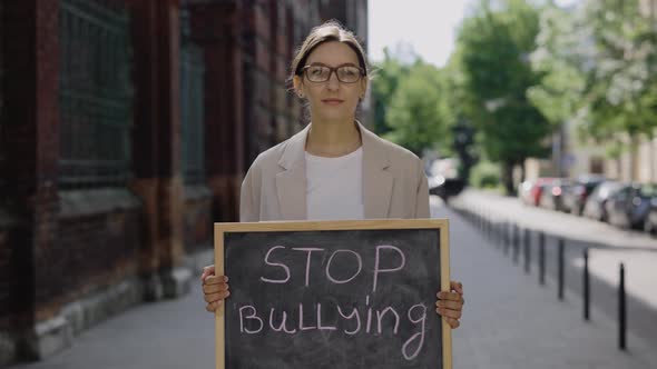 Female Standing on Street Looking at Camera and Protest Against Bullying