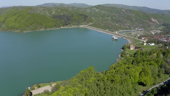 AERIAL - Maneciu dam, hills and forest in Romania, descending wide shot