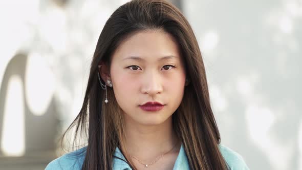 Portrait of Cute Calm Serious Young Chinese Teenager Woman Looking with Emotion to the Camera