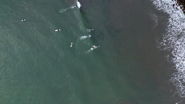 AERIAL: drone, surfers breaking the waves, descending view