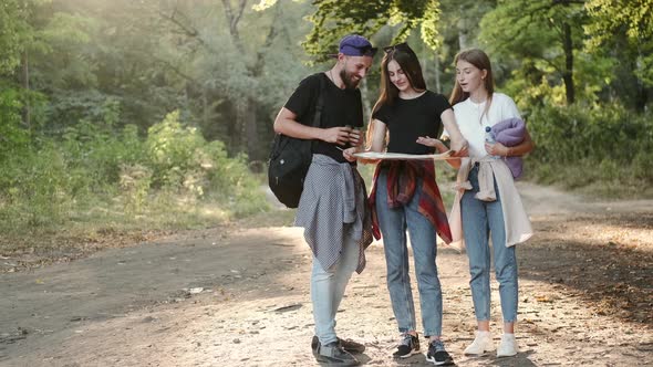 Group of Hikers with Map Going in the Forest