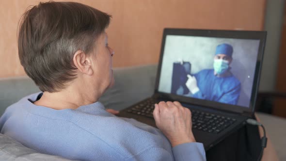 Elderly woman consults with a doctor via video chat at home