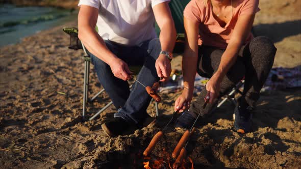 Close Up Shot of People's Hands and Body Who Cooks Meat Sausages at the Stake