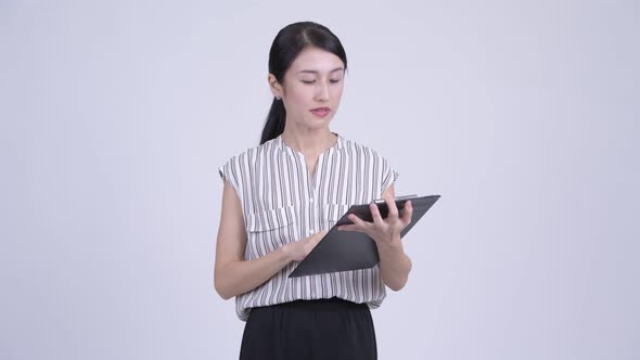 Happy Asian Businesswoman Showing Clipboard and Giving Thumbs Up