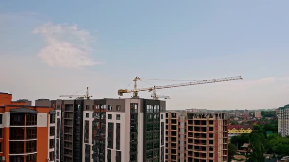 Aerial Drone View. High Cranes Works on Building Site with a House. Wide View