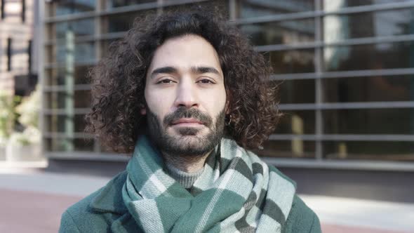 Urban Portrait of the Young Curly Man with Beard Posing on the Street