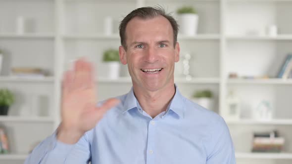 Portrait of Middle Aged Businessman Doing Video Chat and Waving