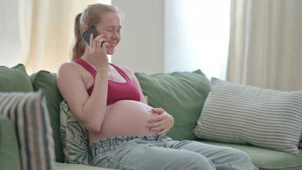 Pregnant Woman Talking on Phone on Sofa