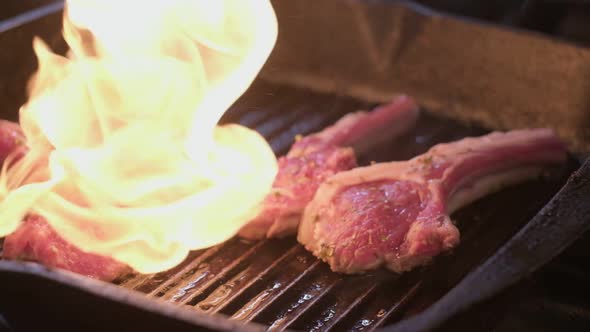 Lamb Ribs in Spices on a Grill are Being Flamed By Gas Burner