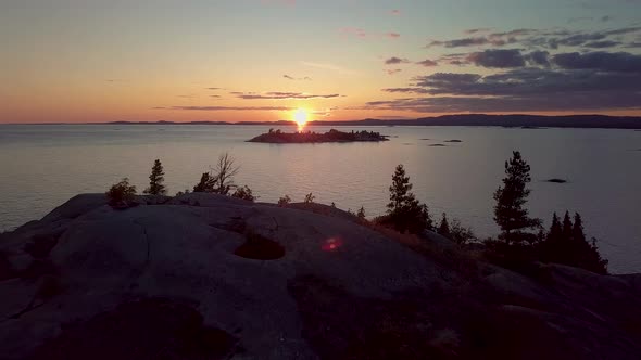 Flying Over Smooth Granite Boulders at Sunset, Drone Aerial Wide Dolly In. View of Island in Blue La