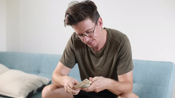 Men's Hands Count Cash Dollars and Other Currencies at Home in a Bright Room