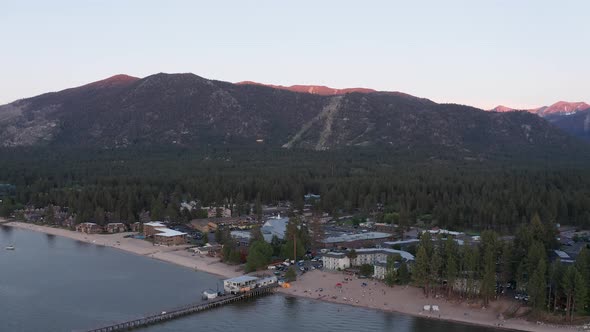 Reverse pullback and panning aerial shot of South Lake Tahoe at low light in the summer. 4K