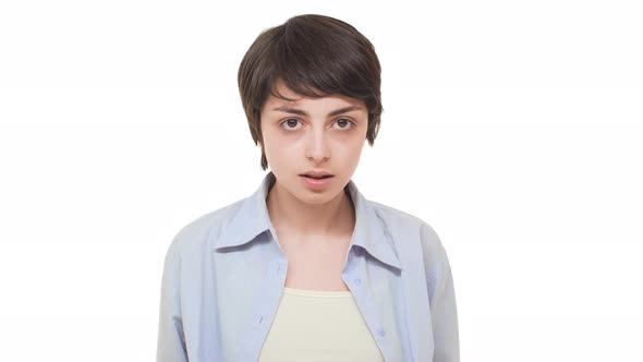 Young Beautiful Caucasian Female with Short Haircut Standing Guilty Over White Background and
