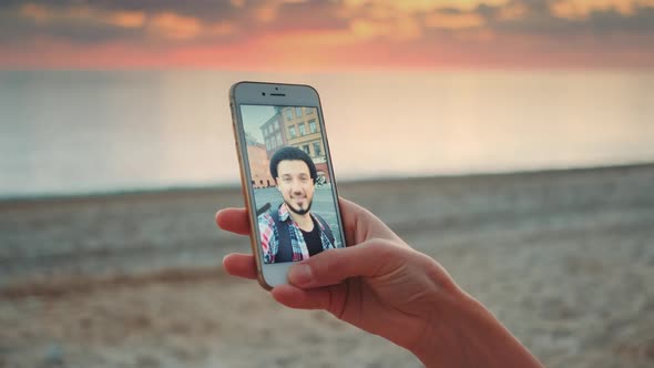 Closeup Shot of Video Call Making with Smartphone on the Seashore