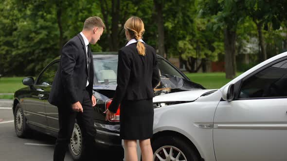 Drivers Observing Car Damage and Arguing After Road Collision on Parking Lot