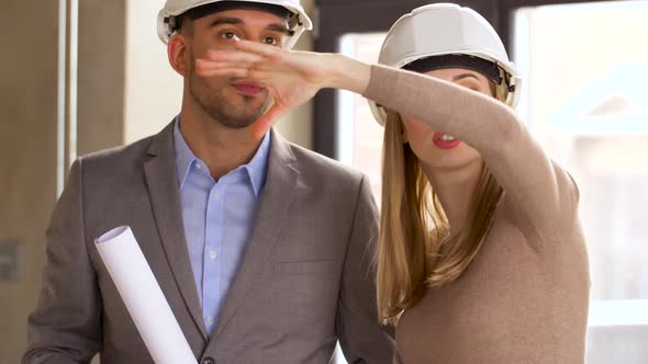 Architects with Blueprint and Helmets at Office 60