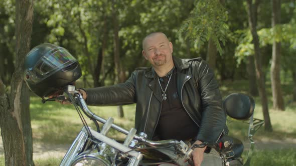 Lifestyle Portrait of Biker Sitting on Motorcycle