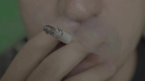 Cigarette in the Mouth of a Smoker. Close-up. Chroma Key. Green Background.