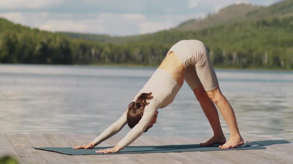 Sportive Woman Having Yoga Practice Outdoors on Lake Pier