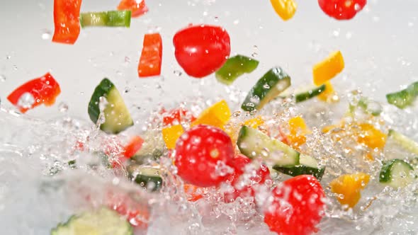 Super Slow Motion Shot of Colorful Vegetables Falling Into Water on White Background at 1000Fps