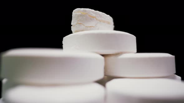 Stack of Soluble Vitamin Tablets Turns on Black Background