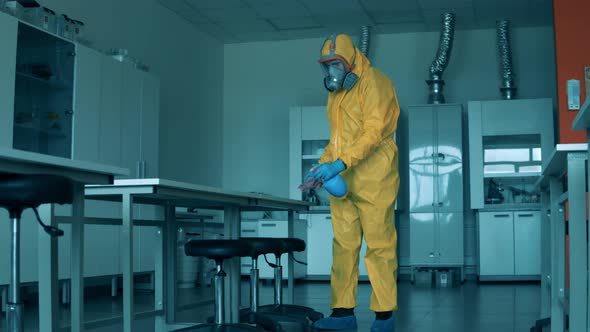 A Man Wipes a Table with Cloth During Disinfection.