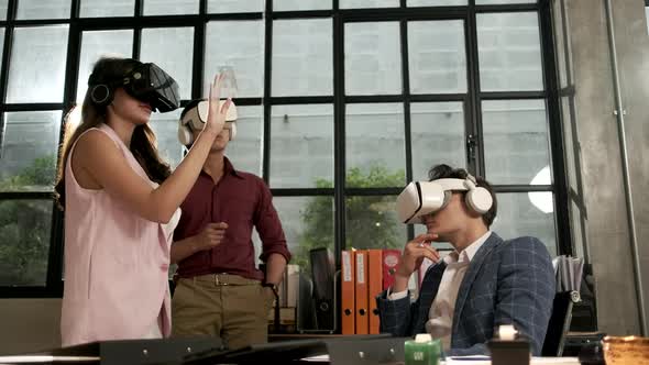 Workers are using VR headsets to visualization cyberspace at business office.