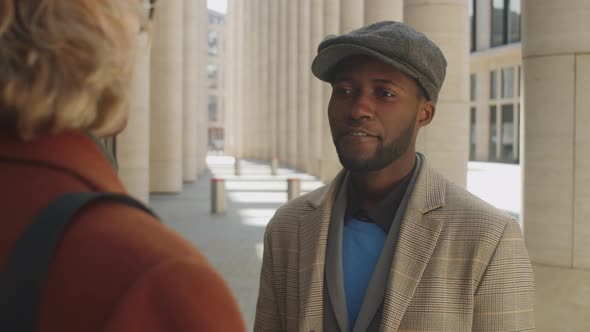 Elegant Afro-American Businessman Talking with Colleague Outdoors